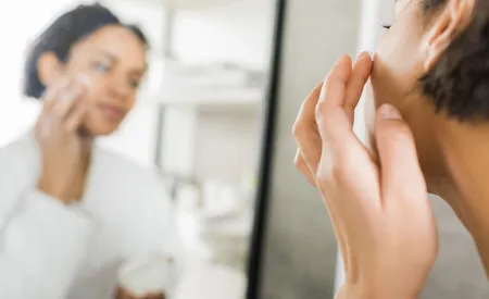 Woman applying cream on her face