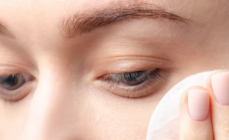 Une femme se passe un coton sur le visage