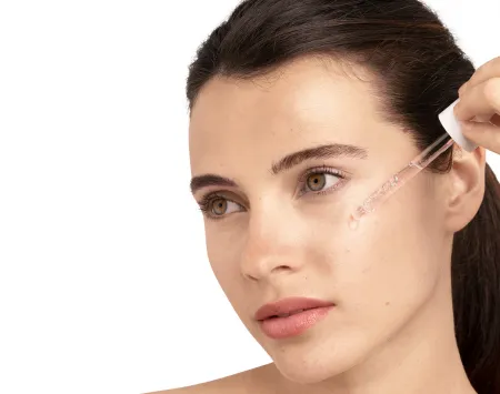 Illustration of a woman applying a serum to her face, emphasizing the use of hyaluronic acid for skincare benefits.